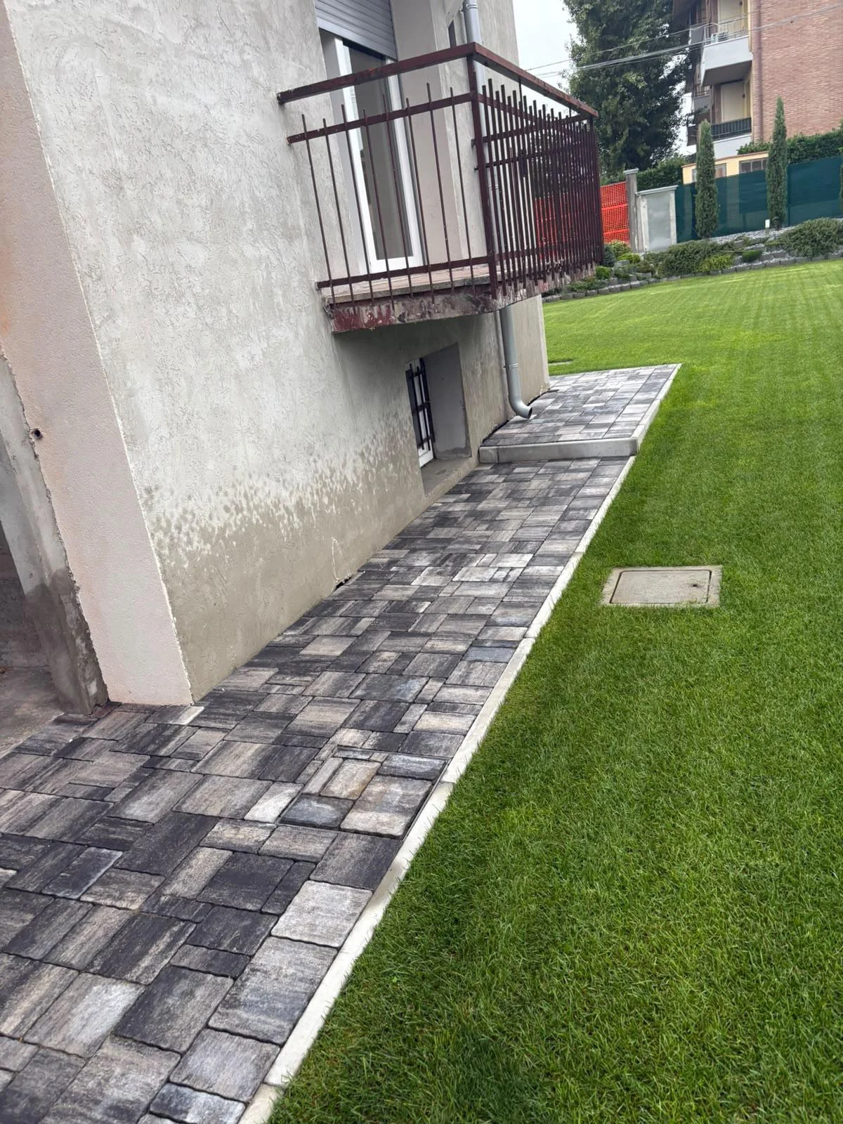 Percorso pavimentato lungo l’edificio e il prato